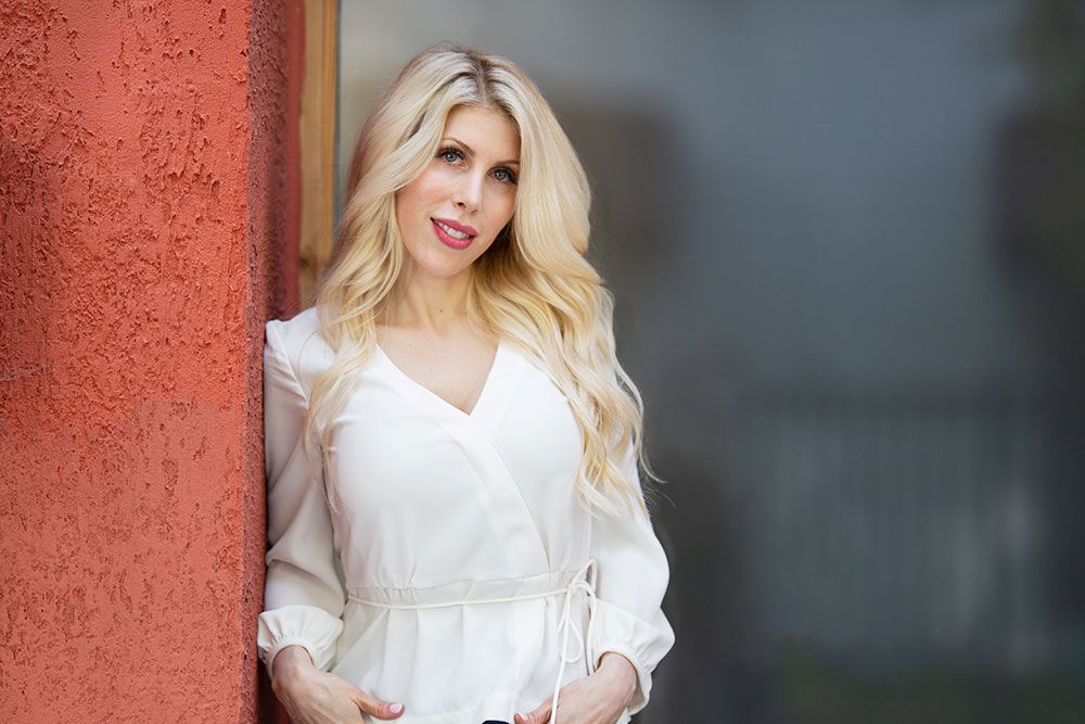 Cheerful woman wearing jeans standing outside